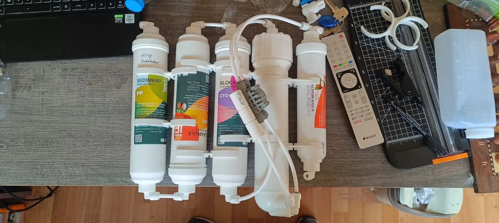 Değişim için hazırlanmış 5 kademeli JF filtre seti ve membran gövdesi — PP sediment, GAC granül karbon, CTO blok karbon, membran ve post-karbon kademeleri ayrı ayrı görünüyor